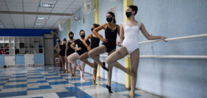 Grupo de meninas apoiado em barra dançando ballet